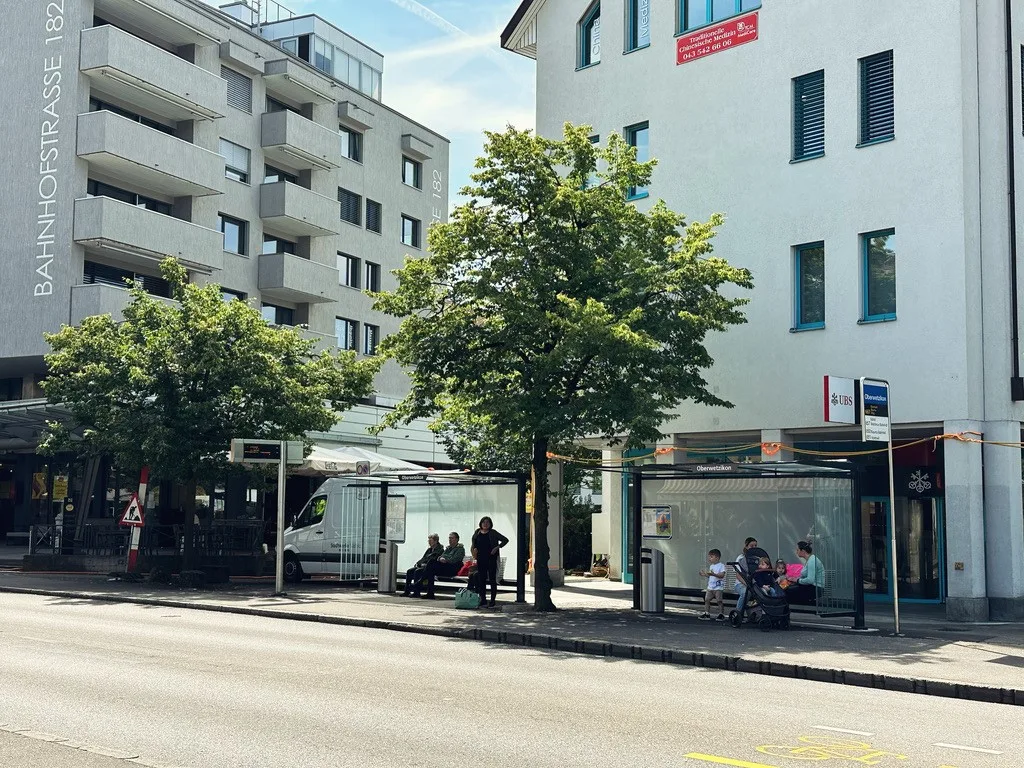 Eine Busstation mit Passanten.